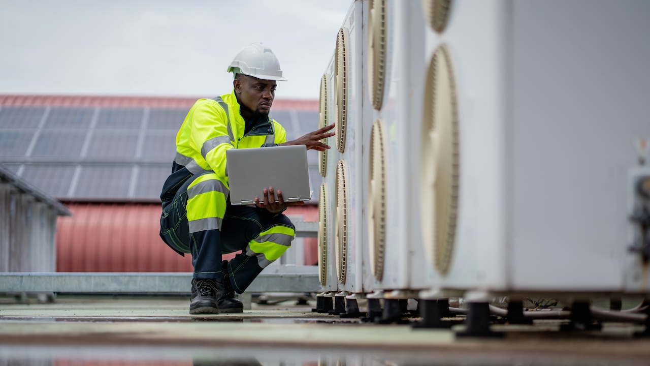 HVAC specialist who is checking the air conditioning cooling system of a major building or industrial facility.