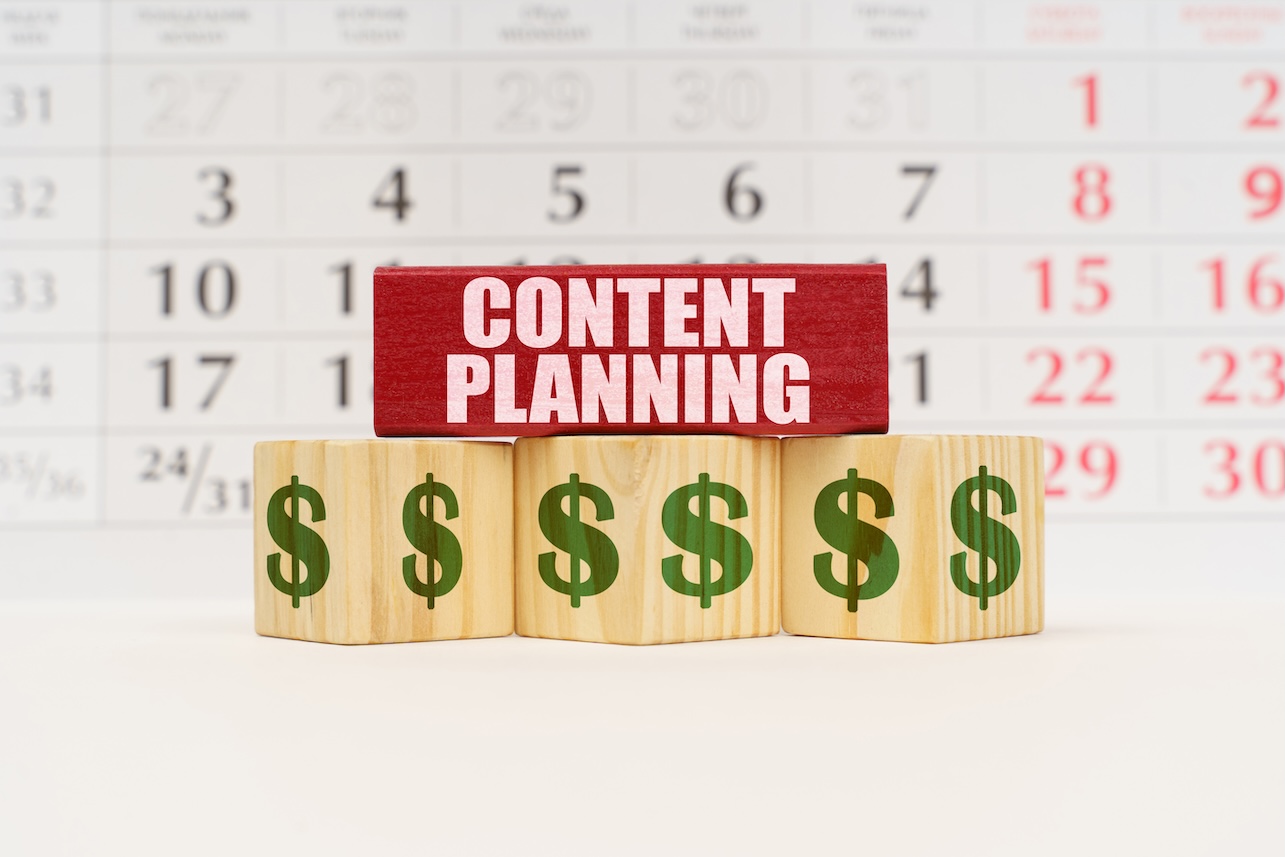 home service-based business content planning concept. Against the background of the calendar there are cubes with the image of the dollar and a red plate with the inscription - CONTENT PLANNING $$$$$$