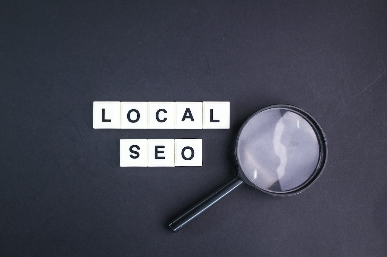 magnifying glass with local seo alphabet words. incredibly effective way to market your near business online